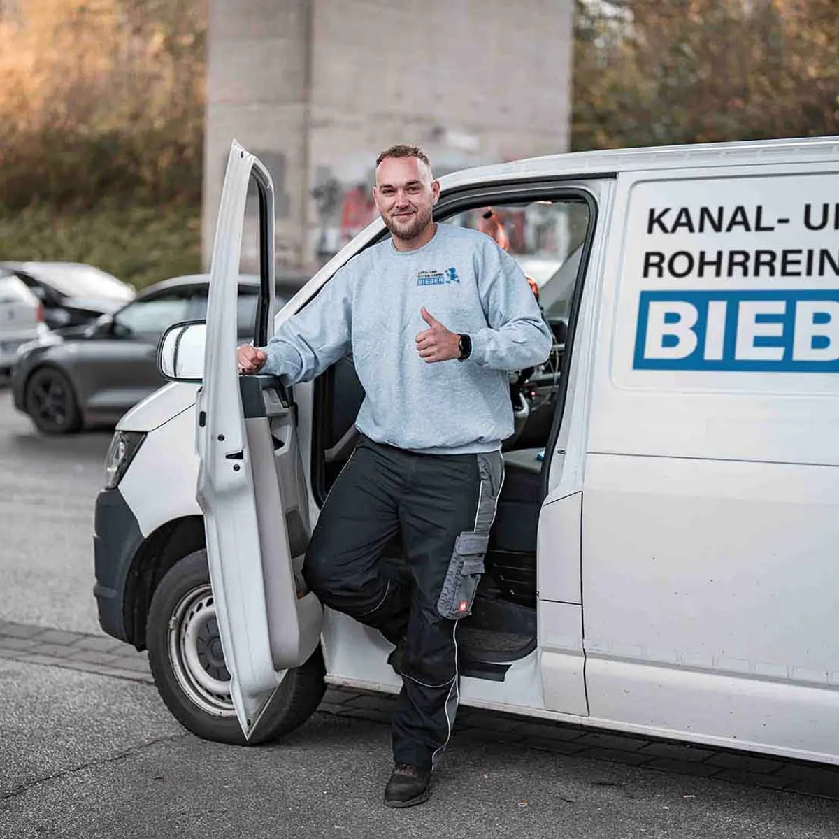 Techniker von Kanal- und Rohrreinigung Bieber am beschrifteten Einsatzfahrzeug